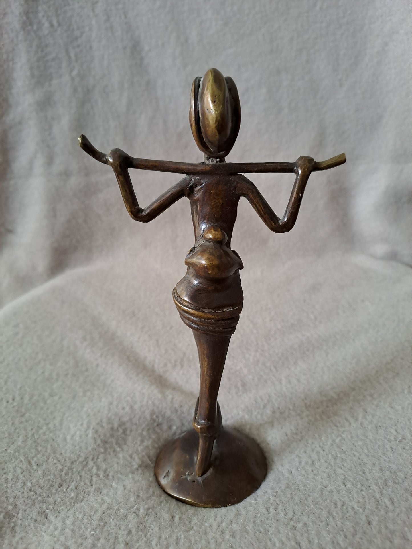 Statue représentant une femme africaine portant un enfant dans le dos.