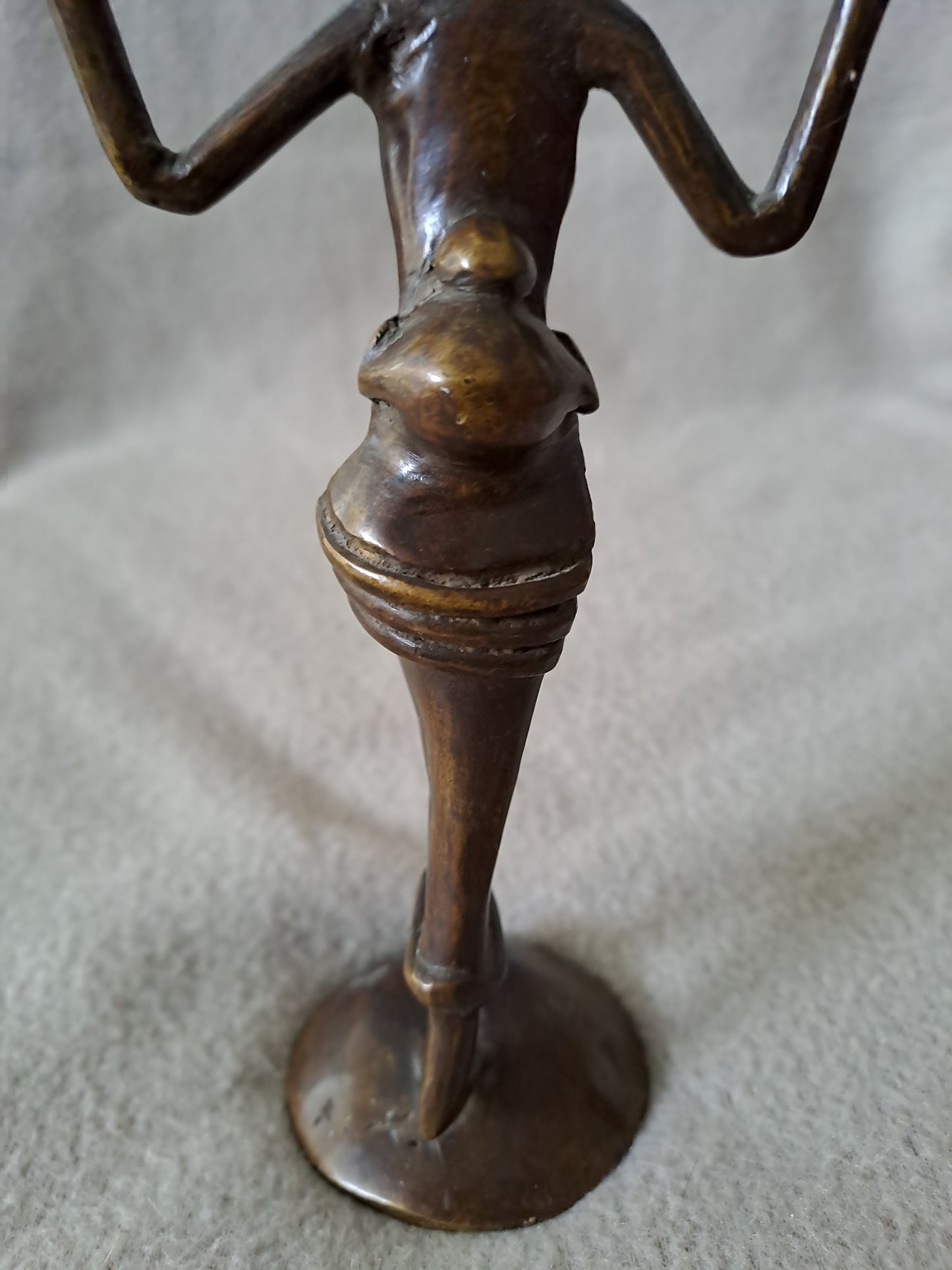 Statue représentant une femme africaine portant un enfant dans le dos.