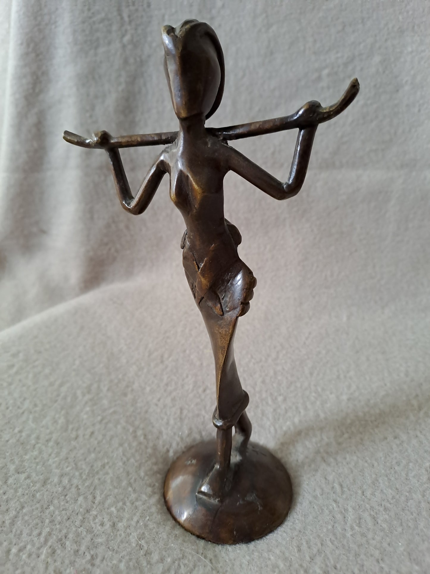 Statue représentant une femme africaine portant un enfant dans le dos.