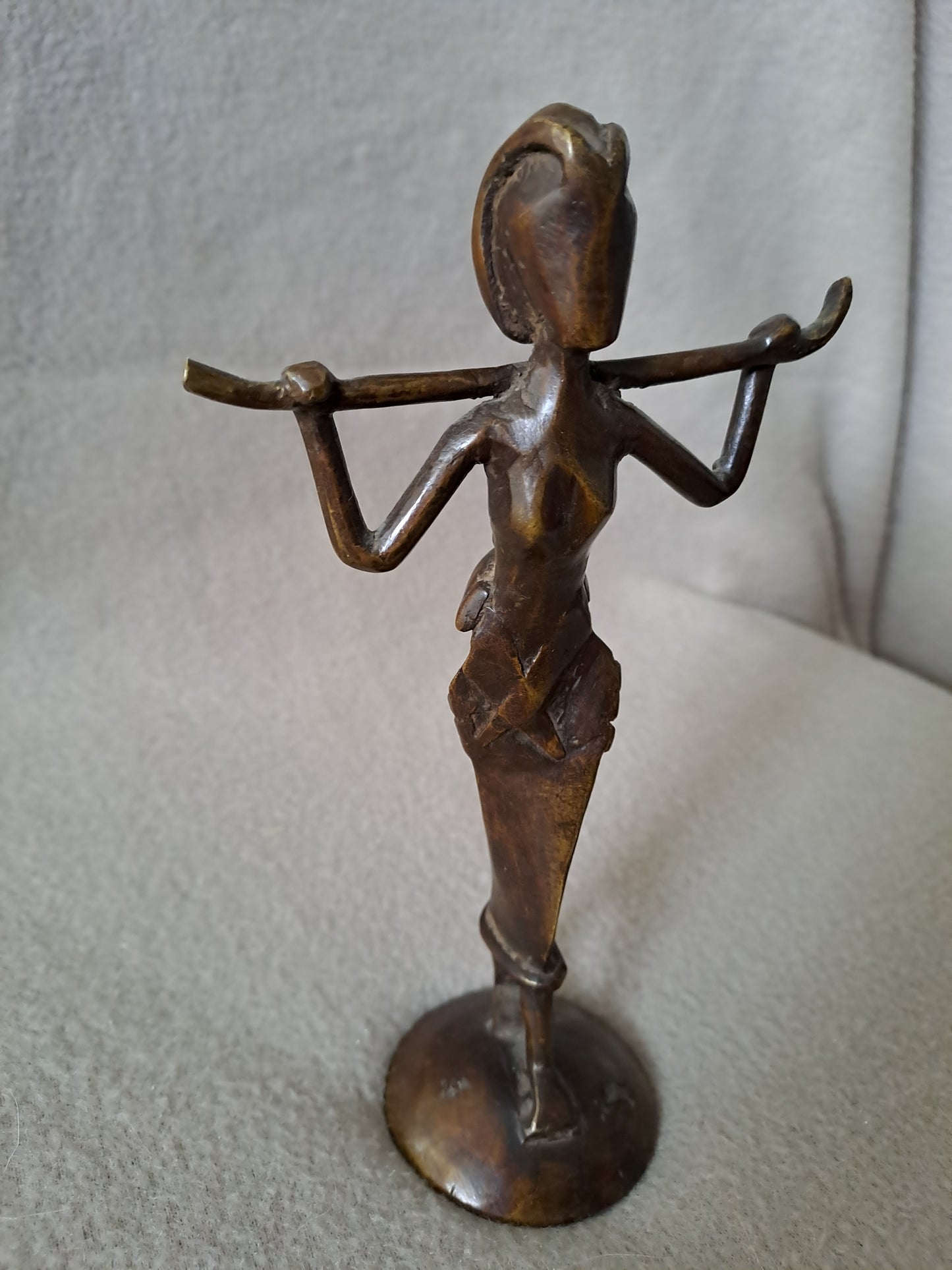 Statue représentant une femme africaine portant un enfant dans le dos.