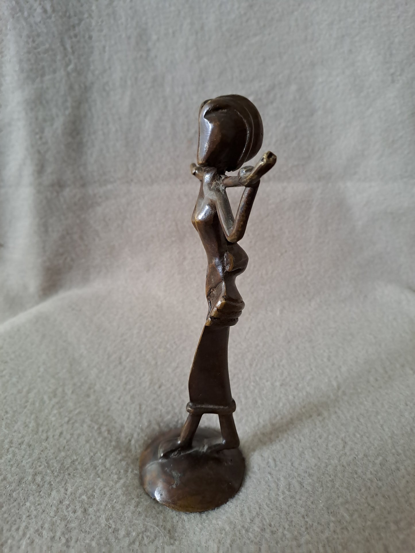 Statue représentant une femme africaine portant un enfant dans le dos.